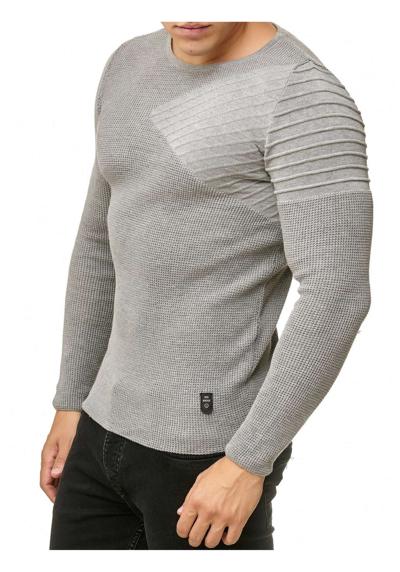 Вязаный свитер с изысканной деталью на плечах.
